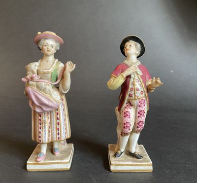 paire de figurines représentant un homme et une femme tenant un bébé dans leurs bras