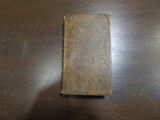 un vieux livre posé sur une table, sur lequel se trouve un petit bout de papier