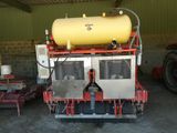un réservoir jaune posé sur une machine dans un garage
