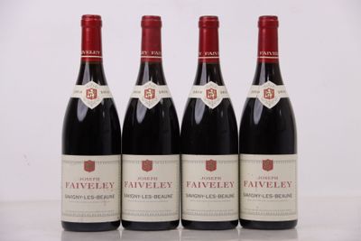 quatre bouteilles de vin rouge sont alignées sur une table