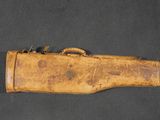 un ancien étui à arme en bois muni d'une poignée en cuir sur un fond noir
