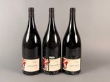 trois bouteilles de vin posées sur une table l'une à côté de l'autre