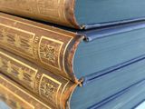 several old books stacked on top of each other on a table
