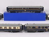four model trains are lined up in a row on a white surface