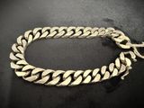 a close up of a silver chain bracelet on a black surface