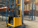 a forklift in a large warehouse with lots of pallets