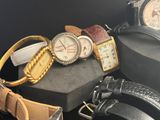 many different watches and bracelets sitting on a table