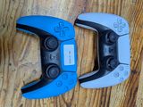 two video game controllers sitting on top of a wooden floor