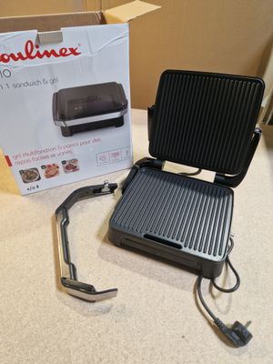 an image of a grill with a box of food in the background