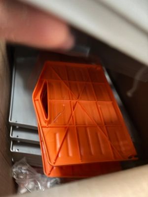 une personne tenant un récipient en plastique dans une boîte en carton