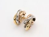 a pair of gold and silver earrings on a white surface
