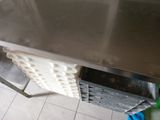 a large stainless steel table with a shelf underneath it