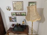 un bureau avec une lampe et des photos accrochées au mur