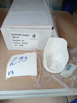 a white bowl sitting on top of a table next to a box