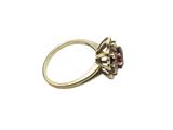 a close up of a gold ring with a ruby stone