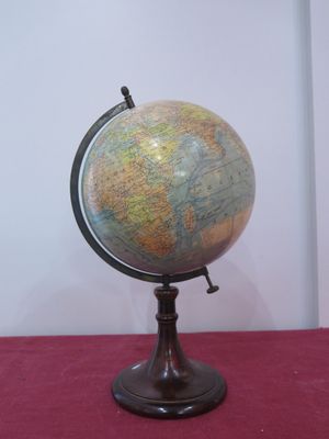 a small globe on a stand on a red table