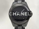 Montre Chanel avec cadran noir et bracelet noir sur fond blanc