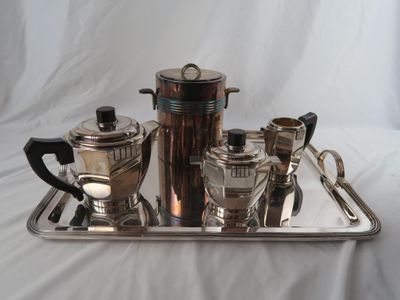 a silver tray with a silver coffee pot and two cups on it