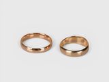 two gold wedding rings on a white background