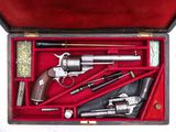 une boîte contenant un pistolet, un revolver et d'autres objets
