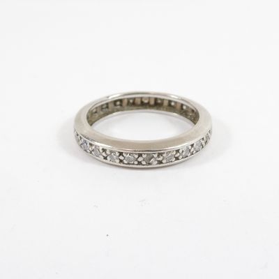 a close up of a diamond ring on a white surface