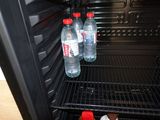 two bottles of water sitting in an open refrigerator