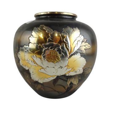 un vase noir orné de fleurs dorées et blanches