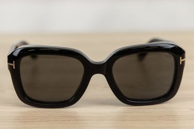 a pair of black sunglasses sitting on top of a wooden table