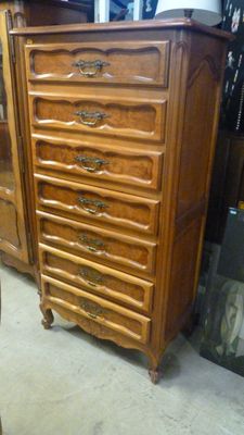 une photo montrant une commode et une chaise dans une pièce