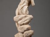 marble statue of a woman on a rock with a bird perched on her head