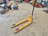 a forklift in a garage with other tools in the background