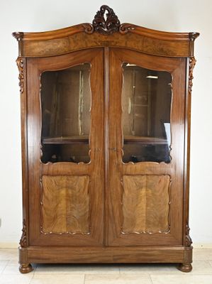 a wooden cabinet with glass doors in a room
