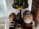 Il y a de nombreux vases et bocaux posés par terre dans cette pièce.