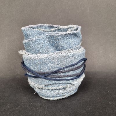 a stack of blue jeans wrapped around each other on a table