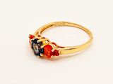 an image of a gold ring with three different colored stones