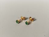 a pair of gold earrings with green stones on them