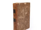 an old book that is sitting on a white surface
