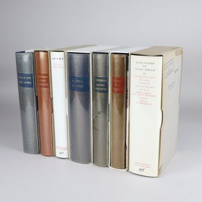 several books are stacked on top of each other in a row