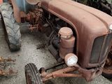 a rusted old tractor sitting in a garage