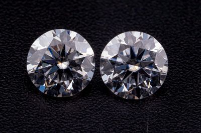 une paire de diamants taille ronde sur un fond noir