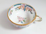 a small cup with a floral design on it