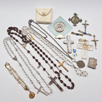 un chapelet et d'autres objets religieux disposés sur une surface blanche