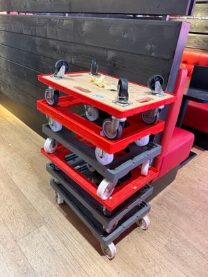 a red cart that has wheels on it in a room