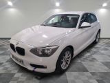 une photo d'une voiture bmw blanche dans une salle d'exposition