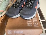 two pairs of running shoes sitting on top of a box on a table