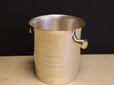 a metal bucket with a handle sitting on a table