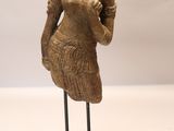 statue d'une femme tenant un vase, posée sur un socle noir