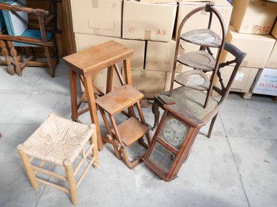 Plusieurs chaises et tabourets sont empilés sur une pile de cartons