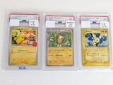trois cartes Pokémon sont dans des pochettes en plastique posées sur une surface blanche