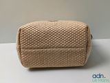 an image of a beige purse sitting on top of a white table